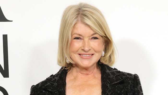Martha Stewart poses in a sequined black blazer and smiles for the camera.
